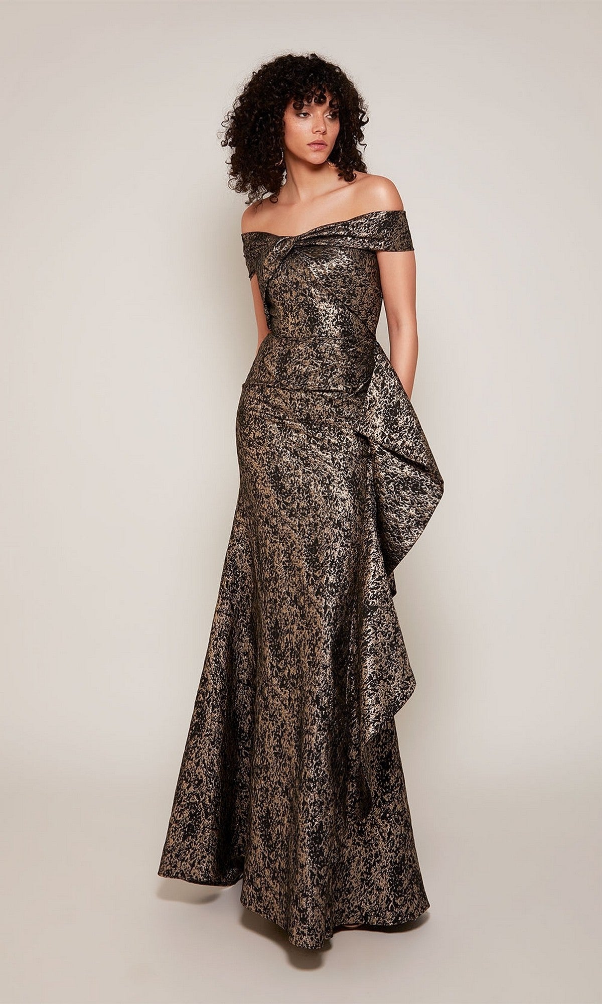 A woman models the Alyce 27667, a long formal off-the-shoulder metallic jacquard gown—an elegant choice for formal events or as a mother-of-the-bride dress.